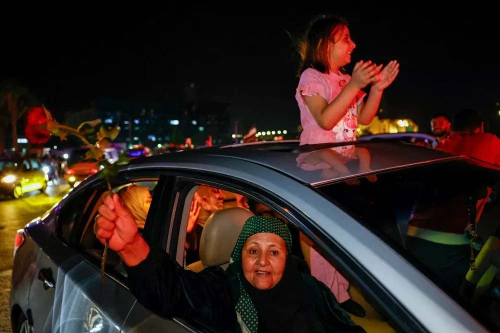 People celebrate after U.S. President Donald Trump said on Tuesday he would order the lifting of sanctions on Syria, in Damascus, Syria May 13, 2025. REUTERS/Yamam Al Shaar