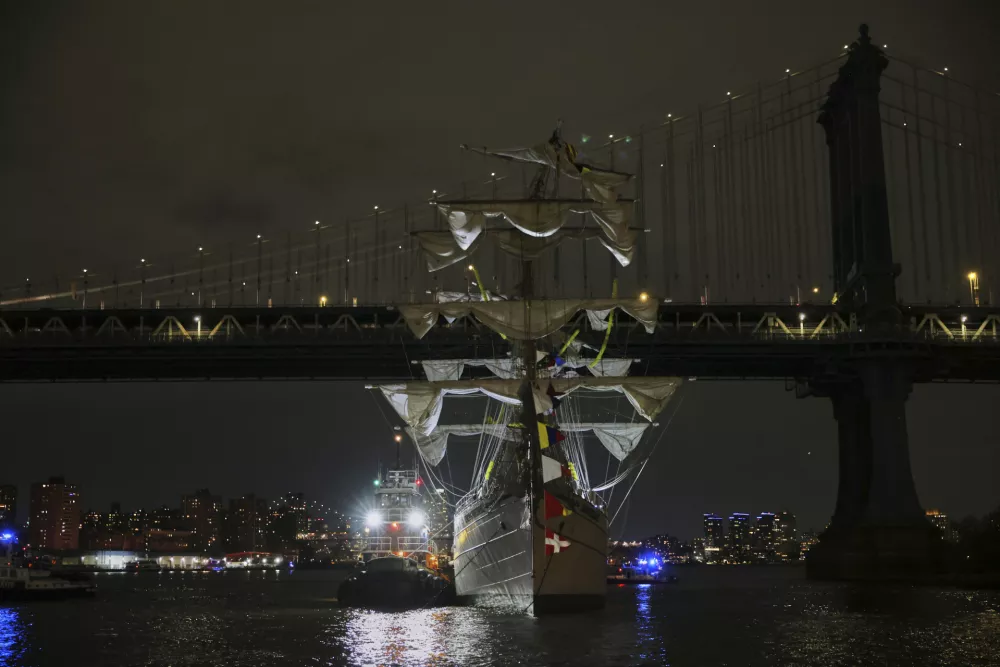 A tug boat helps stabilize the Cuauhtémoc, a masted Mexican Navy training ship as it sits stranded near the Manhattan Bridge after colliding with the Brooklyn Bridge, Saturday, May 17, 2025, in New York. (AP Photo/Yuki Iwamura)