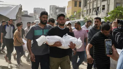Saleh Zenati, carries the body of his infant nephew Khalid Zenati killed in an Israeli army airstrike, during his funeral in Khan Younis, Gaza Strip, Sunday, May 18, 2025. (AP Photo/Abdel Kareem Hana)