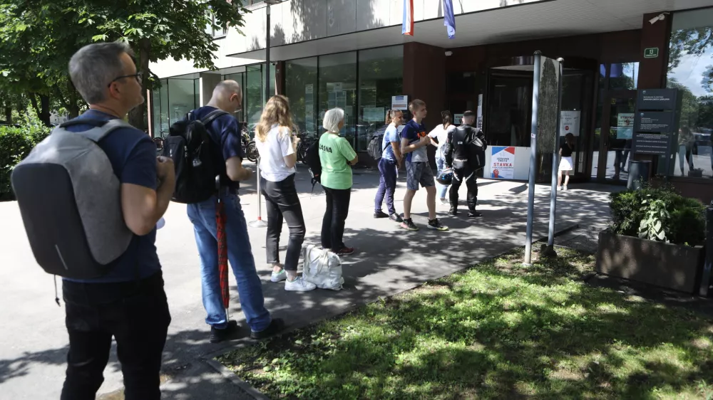 Lani se je pred Upravno enoto Ljubljana vila vrsta čakajočih. Takšnih čakalnih vrst letos sicer ni več, kljub temu pa se zaostanki tudi tukaj spet izrazito kopičijo.
Foto: Luka Cjuha