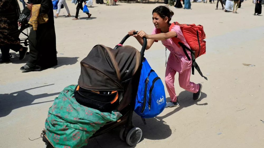 A girl pushes a stroller with belongings as Palestinians flee their homes after the Israeli military issued orders for evacuation from eastern Khan Younis, in the southern Gaza Strip, May 19, 2025. REUTERS/Hatem Khaled   TPX IMAGES OF THE DAY