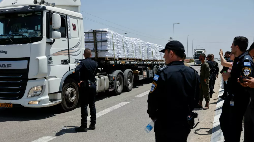Israeli security forces members stand near trucks with aid entering from Israel into Gaza, near the Kerem Shalom crossing near the Israeli border with Gaza May 21, 2025 REUTERS/Amir Cohen