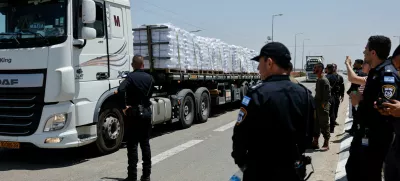 Israeli security forces members stand near trucks with aid entering from Israel into Gaza, near the Kerem Shalom crossing near the Israeli border with Gaza May 21, 2025 REUTERS/Amir Cohen