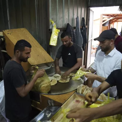 Palestinians bake bread after the World Food Program was able to bring in flour for the first time in over a month as Israel allowed some aid to enter the Gaza Strip, in Deir al-Balah, Gaza Strip, Thursday, May 22, 2025. (AP Photo/Abdel Kareem Hana)