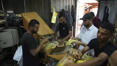 Palestinians bake bread after the World Food Program was able to bring in flour for the first time in over a month as Israel allowed some aid to enter the Gaza Strip, in Deir al-Balah, Gaza Strip, Thursday, May 22, 2025. (AP Photo/Abdel Kareem Hana)