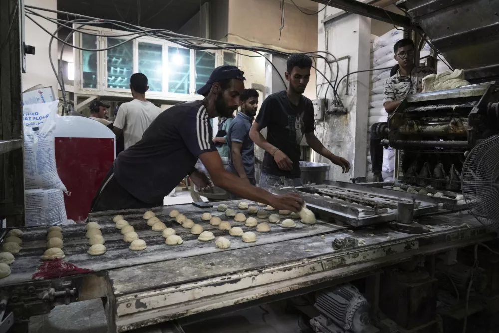 Palestinians bake bread after the World Food Program was able to bring in flour for the first time in over a month as Israel allowed some aid to enter the Gaza Strip, in Deir al-Balah, Gaza Strip, Thursday, May 22, 2025. (AP Photo/Abdel Kareem Hana)