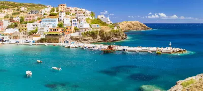 Harbour with marine vessels, boats and lighthouse. Panoramic view from a cliff on a Bay with a beach and architecture Bali - vacation destination resort, with secluded beaches and clear turquoise ocean waters, Rethymno, Crete, Greece