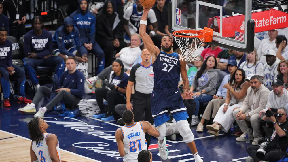 May 24, 2025; Minneapolis, Minnesota, USA; Minnesota Timberwolves center Rudy Gobert (27) goes in for a dunk against Oklahoma City Thunder guard Aaron Wiggins (21) during the second half in game three of the western conference finals for the 2025 NBA Playoffs at Target Center. Mandatory Credit: Brad Rempel-Imagn Images