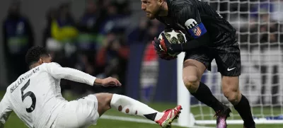 Atletico Madrid's goalkeeper Jan Oblak saves in front of Real Madrid's Jude Bellingham during the Champions League round of 16, second leg, soccer match between Atletico Madrid and Real Madrid at the Metropolitano stadium in Madrid, Spain, Wednesday, March 12, 2025. (AP Photo/Bernat Armangue)