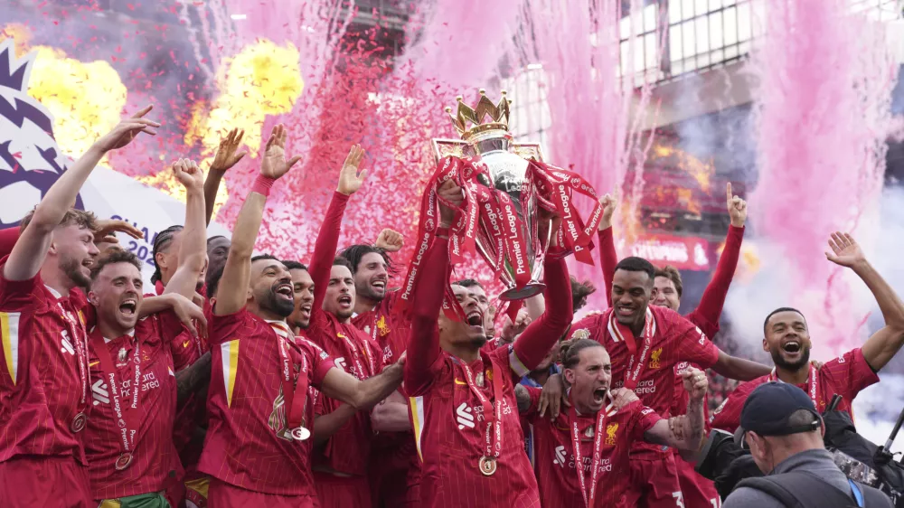 Liverpool players celebrate with the winner's trophy after the English Premier League soccer match between Liverpool and Crystal Palace at the Anfield stadium in Liverpool, England, Sunday, May 25, 2025. (AP Photo/Jon Super)