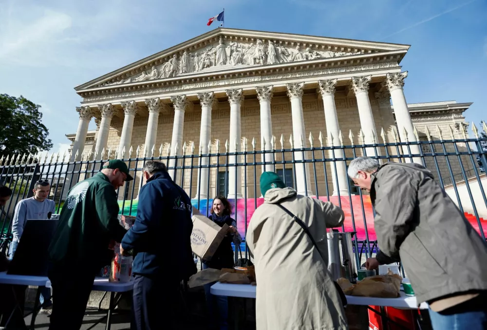 French farmers have breakfast in front of the French parliament, the Assemblee Nationale, as they gather for a protest to call on lawmakers to adopt a bill that would loosen restrictions on pesticide and water use in farming, in Paris, France May 26, 2025. REUTERS/Abdul Saboor