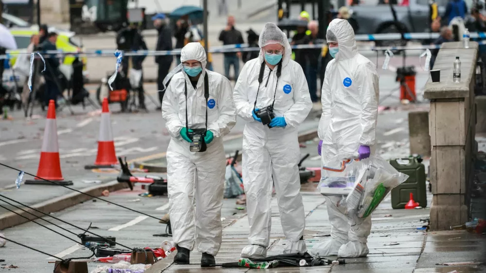 Forensic officers work near the site of an incident where a car plowed into a crowd of Liverpool fans during a parade celebrating their side's Premier League soccer title, in central Liverpool, Britain, May 27, 2025. REUTERS/Phil Noble