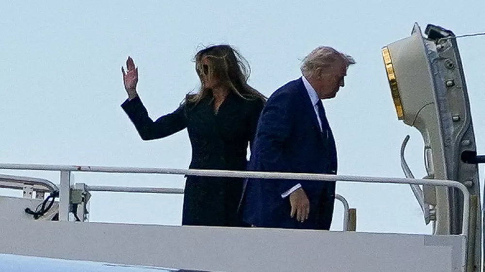 U.S. first lady Melania Trump waves next to President Donald Trump as they board Air Force One at Fiumicino Airport, while they leave after attending the funeral Mass of Pope Francis, near Rome, Italy, April 26, 2025. REUTERS/Nathan Howard
