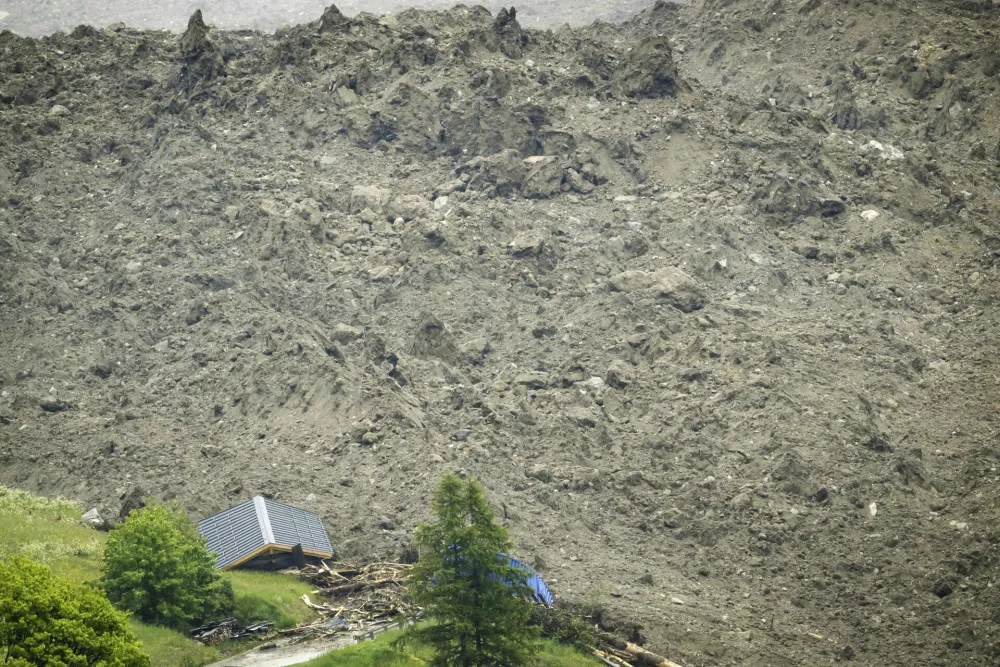 A large avalanche with a mixture of ice, rock, snow and water reach the valley floor is pictured in Wiler after the Birch glacier collapsing above Blatten, Switzerland, Wednesday, May 28, 2025. (Jean-Christophe Bott/Keystone via AP)
