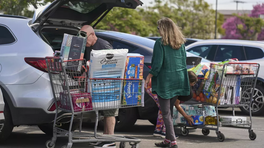 FILE - People pack their supplies into their vehicles at Costco Wholesale store in Burbank, Calif., on Thursday, April 10, 2025. (AP Photo/Damian Dovarganes, File)