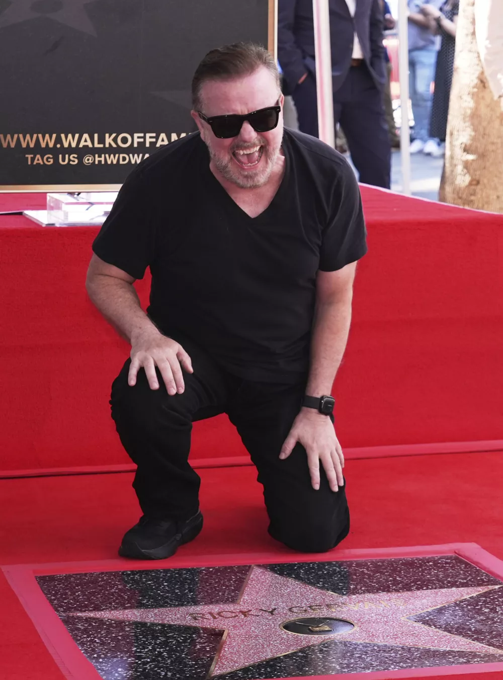 Comedian Ricky Gervais laughs as he poses behind his new star on the Hollywood Walk of Fame on Friday, May 30, 2025, in Los Angeles. (AP Photo/Chris Pizzello)