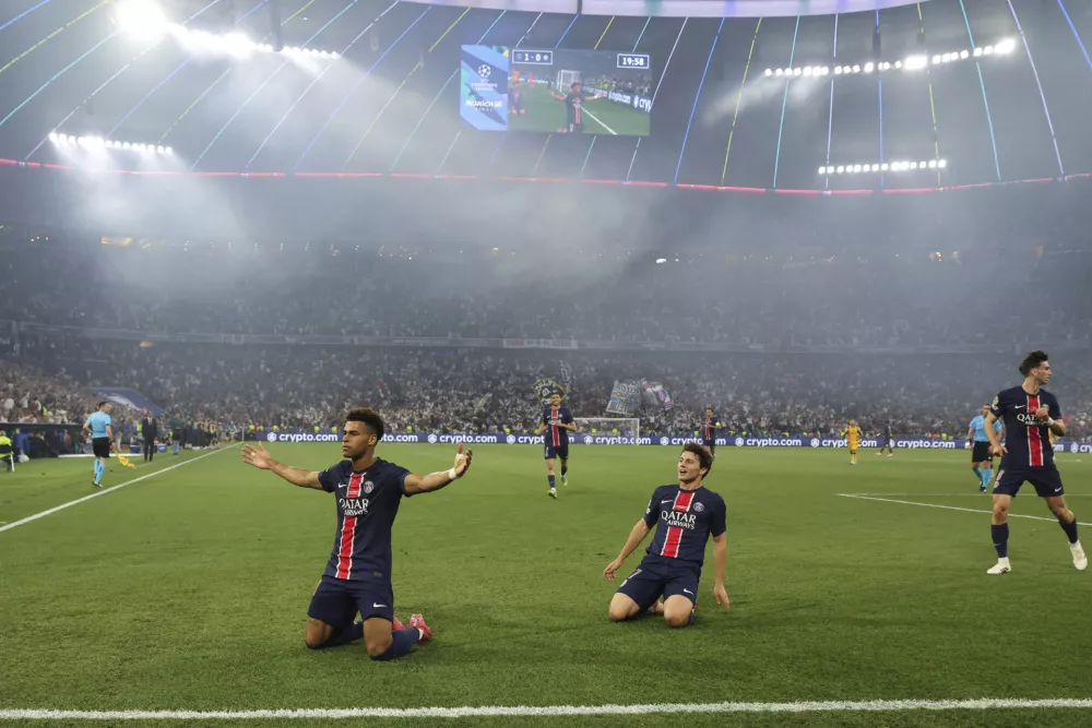 PSG's Desire Doue, left, celebrates after scoring his side's second goal during the Champions League final soccer match between Paris Saint Germain and Inter Milan, at the Allianz Arena in Munich, Germany, Saturday, May 31, 2025. (Christian Charisius/dpa via AP)