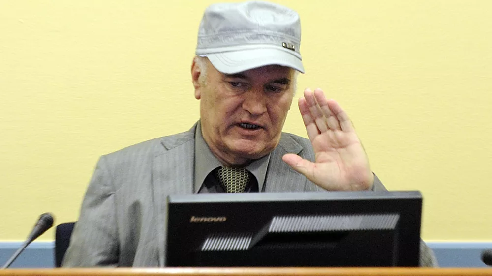 Former Bosnian Serb General Ratko Mladic salutes in the court room during his initial appearance at the U.N.'s Yugoslav war crimes tribunal in The Hague, Netherlands, Friday, June 3, 2011.Mladic's appearance Friday at the Yugoslav war crimes tribunal in The Hague is his first public appearance since he went into hiding nearly 16 years ago, when he was indicted for genocide and war crimes committed in the 1992-95 Bosnian war. (AP Photo/Martin Meissner, Pool)