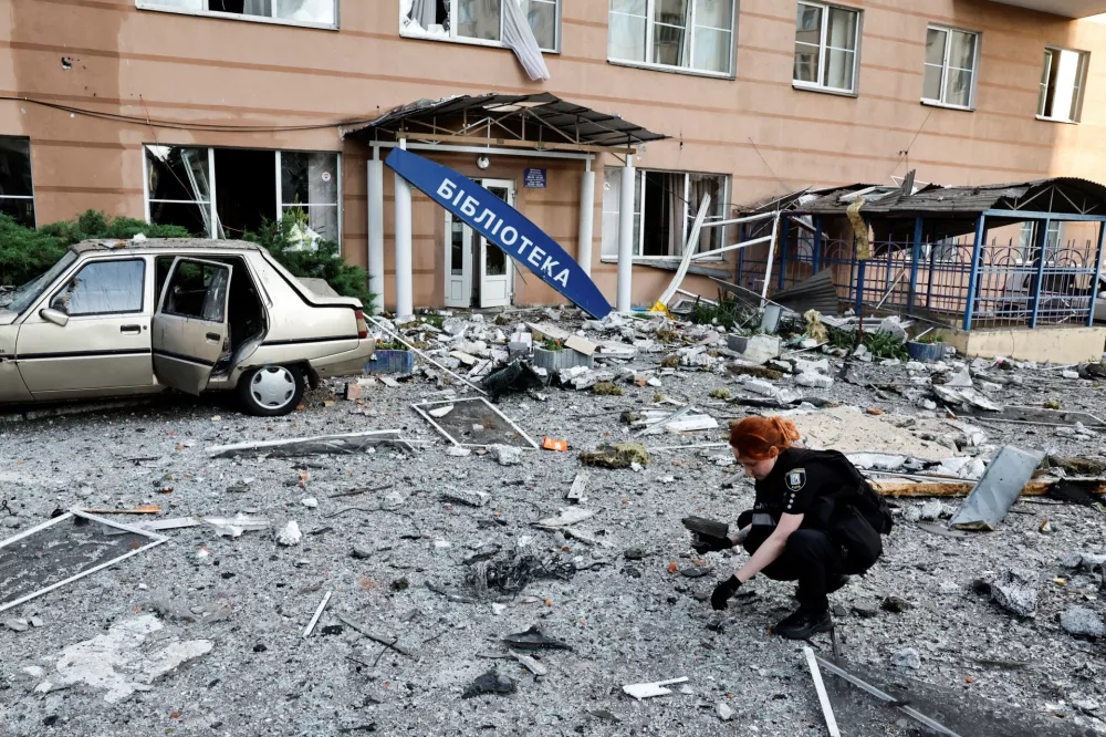 An investigator searches for drone debris at the site where a Russian drone struck an apartment building, amid Russia's attack on Ukraine, in Kyiv, Ukraine June 6, 2025. REUTERS/Thomas Peter