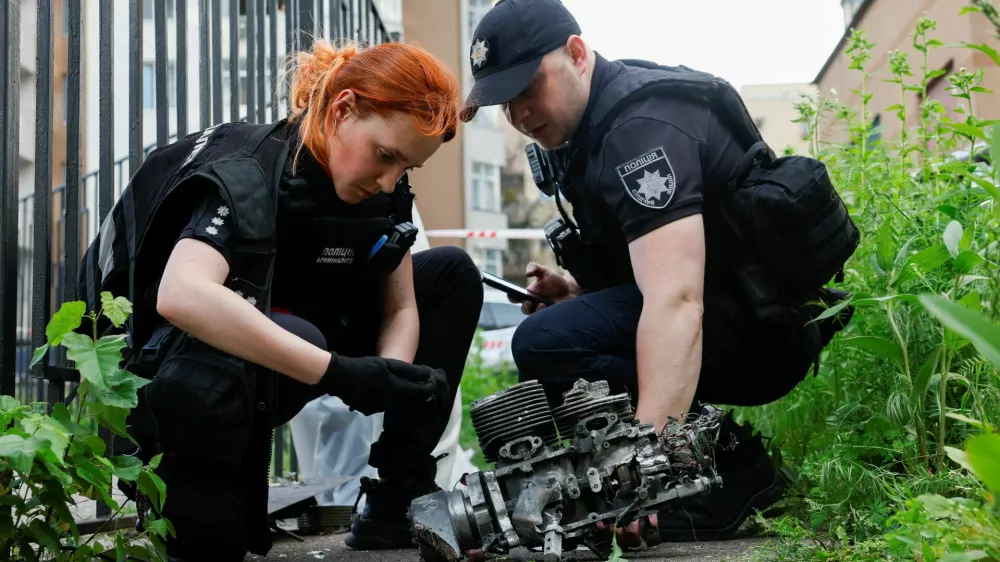 Investigators look at what they say is the engine of a Russian Geran drone after it slammed into an apartment building during a Russian drone strike, amid Russia's attack on Ukraine, in Kyiv, Ukraine June 6, 2025. REUTERS/Thomas Peter