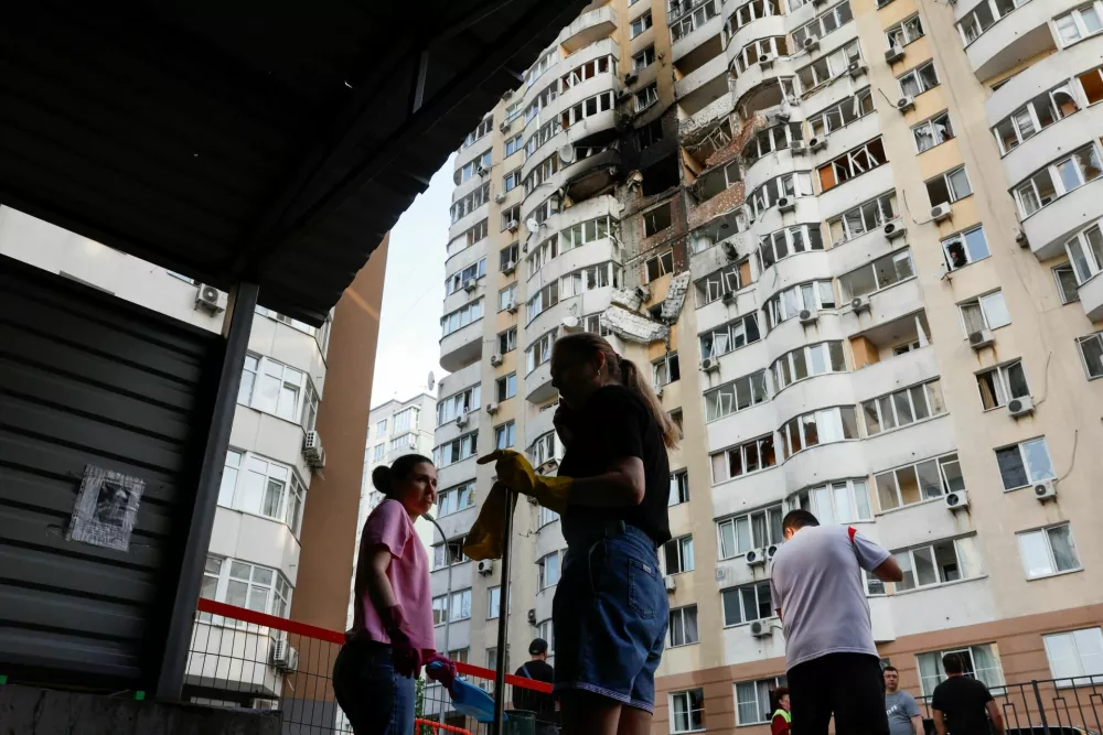 Locals clean up after a Russian drone struck an apartment building, amid Russia's attack on Ukraine, in Kyiv, Ukraine June 6, 2025. REUTERS/Thomas Peter