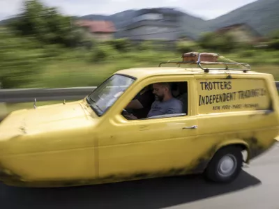 Tarik Fatic along with his brother Mirnes drives the Reliant Regal, an exact copy of the famous BBC TV show  "Only Fools and Horses" iconic yellow car in Sarajevo, Bosnia, Wednesday, June 4, 2025. (AP Photo/Armin Durgut)