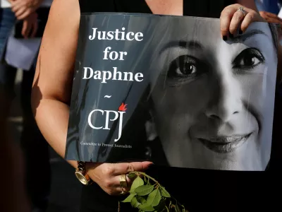 A person holds a placard depicting Daphne Caruana Galizia, prepared by Committee to Protect Journalists (CPJ), as people gather at the site where anti-corruption journalist was assassinated in a car bomb one year ago, in Bidnija, Malta October 16, 2018. REUTERS/Darrin Zammit Lupi - RC16E46980D0
