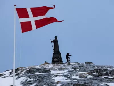 FILE PHOTO: A man walks as Danish flag flutters next to Hans Egede Statue ahead of a March 11 general election in Nuuk, Greenland, March 9, 2025. REUTERS/Marko Djurica/File Photo