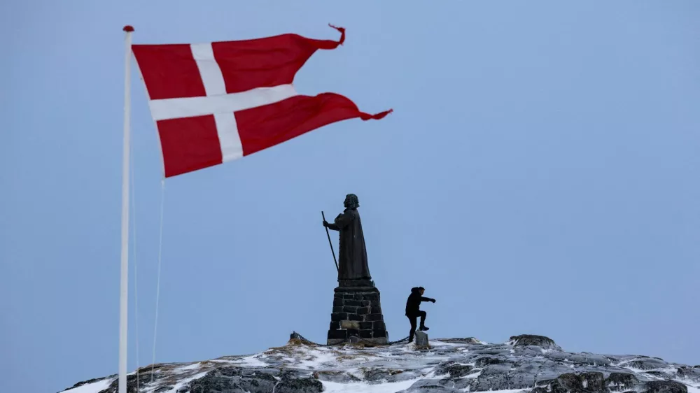 FILE PHOTO: A man walks as Danish flag flutters next to Hans Egede Statue ahead of a March 11 general election in Nuuk, Greenland, March 9, 2025. REUTERS/Marko Djurica/File Photo