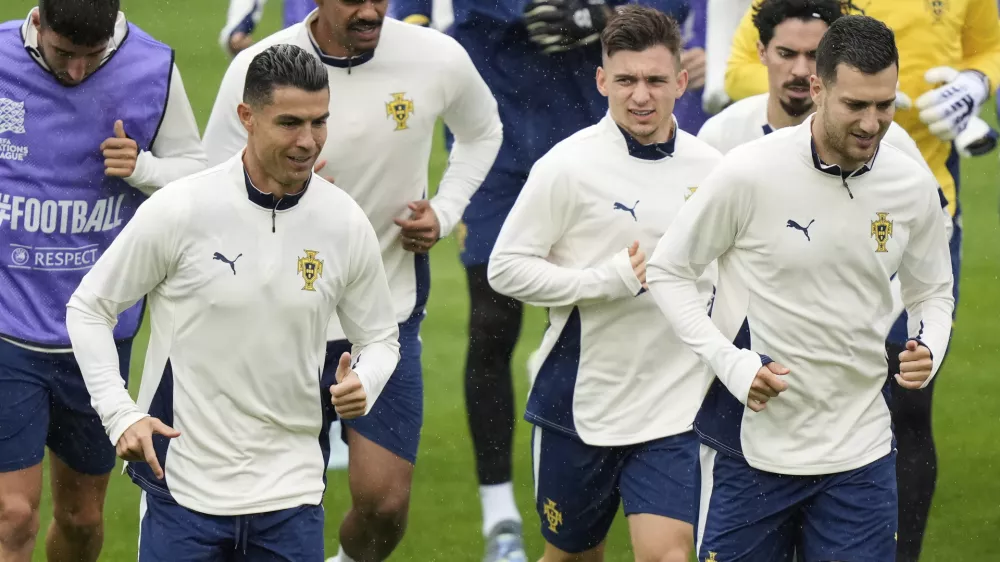 Portugal's Cristiano Ronaldo, left, and team mate Francisco Conceicao, center, warm up during a training session ahead of the Nations League soccer final match between Spain and Portugal in Munich, Germany, Saturday, June 7, 2025. (AP Photo/Matthias Schrader)