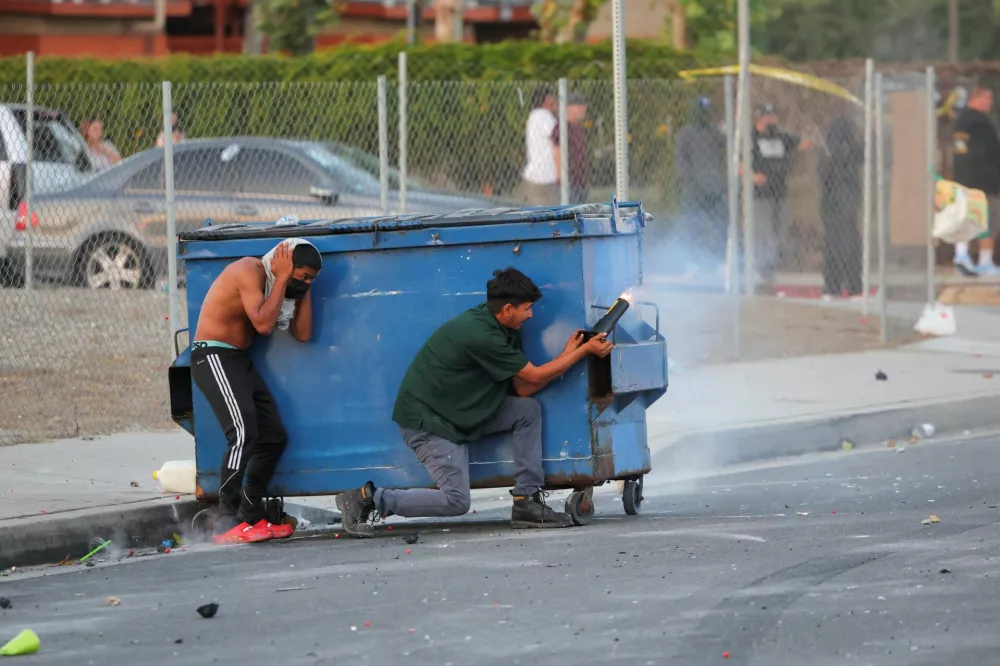 A protesters fires a firework during a standoff between police and protesters following multiple detentions by Immigration and Customs Enforcement (ICE), in the Los Angeles County city of Paramount, California, U.S., June 7, 2025.  REUTERS/Daniel Cole / Foto: Daniel Cole