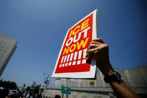 A demonstrator holds a sign during a protest against federal immigration sweeps, outside the Edward R. Roybal federal building, following the deployment of members of the California National Guard by U.S. President Donald Trump in response to protests, in Los Angeles, California, U.S., June 8, 2025. REUTERS/Mike Blake