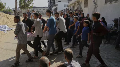 Palestinians carry the body of a person who died last night while trying to get access to humanitarian aid, near the al-Shifa Hospital, in Gaza City, Wednesday, June 11, 2025. (AP Photo/Jehad Alshrafi)