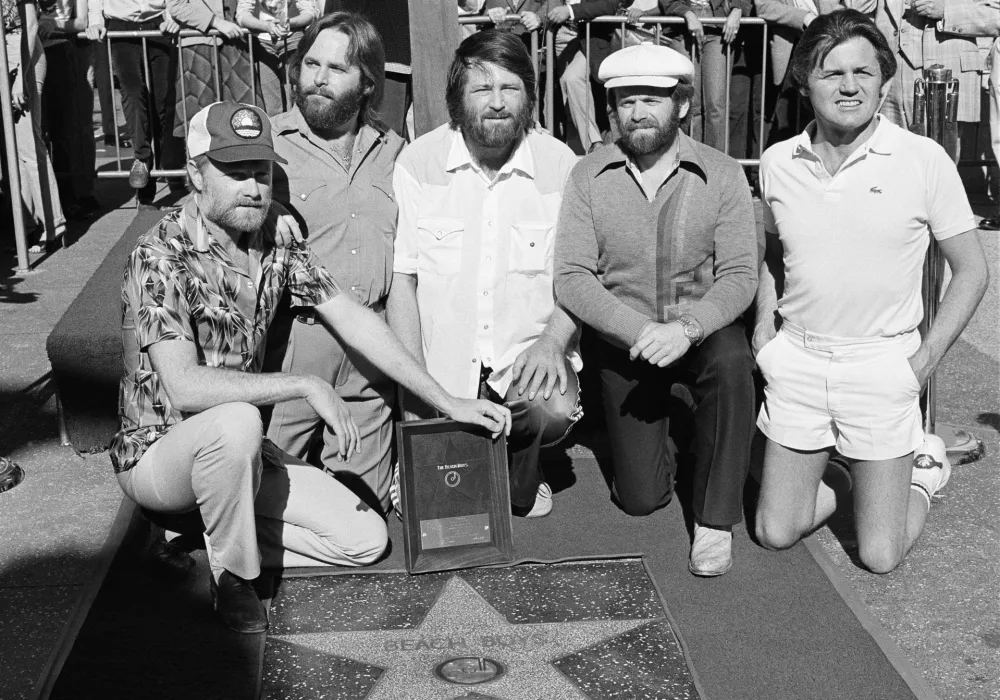 Members of The Beach Boys, from left, Mike Love, Carl Wilson, Brian Wilson, Al Jardine and Bruce Johnston, pose with their star on the Hollywood Walk of Fame, during a ceremony in Los Angeles on Dec. 30, 1980. (AP Photo/Lennox McLendon, File)