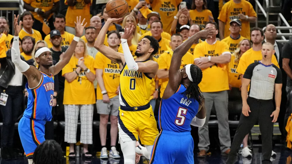 Jun 11, 2025; Indianapolis, Indiana, USA; Indiana Pacers guard Tyrese Haliburton (0) shoots the ball against Oklahoma City Thunder guard Shai Gilgeous-Alexander (2) and guard Luguentz Dort (5) in game three of the 2025 NBA Finals at Gainbridge Fieldhouse. Mandatory Credit: Kyle Terada-Imagn Images