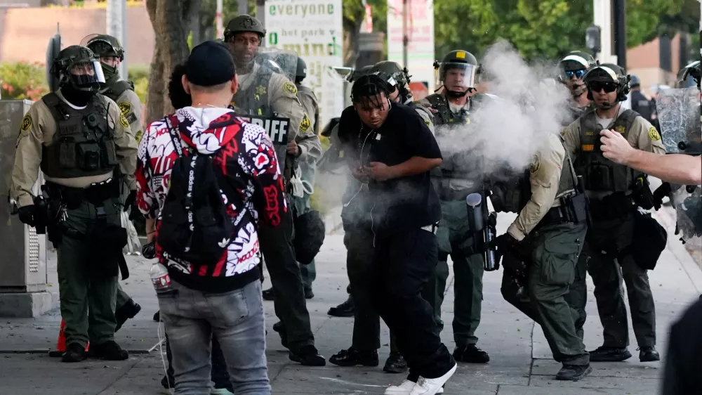 A person reacts to non-lethal munitions shot by a member of the law enforcement, as people protest against federal immigration sweeps, in downtown Los Angeles, California, U.S. June 11, 2025. REUTERS/David Ryder