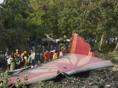 People stand around the debris of an airplane after it crashed in India's northwestern city of Ahmedabad in Gujarat state, Thursday, June 12, 2025. (AP Photo/Ajit Solanki)