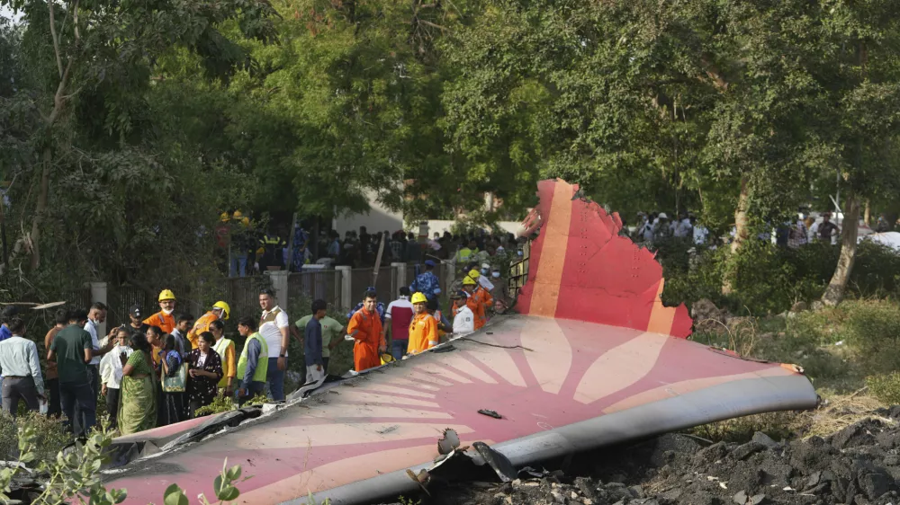 People stand around the debris of an airplane after it crashed in India's northwestern city of Ahmedabad in Gujarat state, Thursday, June 12, 2025. (AP Photo/Ajit Solanki)