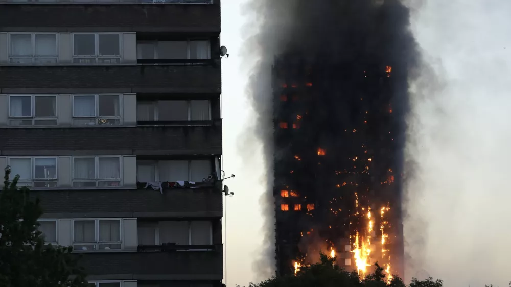 FILE - In this Wednesday, June 14, 2017 file photo smoke and flames rise from the Grenfell Tower high-rise building in west London. (AP Photo/Matt Dunham, File)