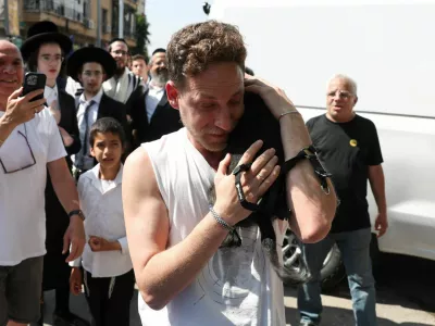Eli Bachar, 40, reacts as he holds his dog Tess, who was rescued from a building that was hit at an impact site following missile attack from Iran on Israel, in Ramat Gan, Israel, June 14, 2025. REUTERS/Ronen Zvulun