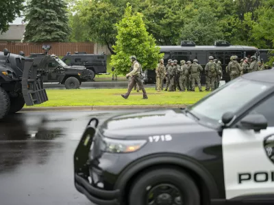 Law enforcement officers including local police, sheriffs and the FBI, stage less than a mile from a shooting in Brooklyn Park, Minn. on Saturday, June 14, 2025. (Alex Kormann/Star Tribune via AP)