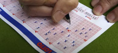 A man fills in a lottery ticket at a Lotto receiving office in Dortmund October 6, 2006. This Saturday the German public lottery 'Lotto' will distribute a total of around 35 million euros, which is the highest lottery jackpot in Germnay since the start of Lotto in 1955.    REUTERS/Ina Fassbender (GERMANY)