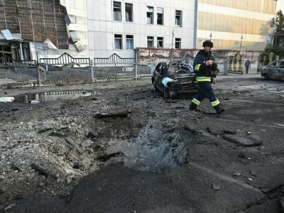A rescuer walks next to destroyed cars and a building of shopping mall damaged by a Russian drone strike, amid Russia's attack on Ukraine, in Zaporizhzhia, Ukraine June 14, 2025. REUTERS/Stringer