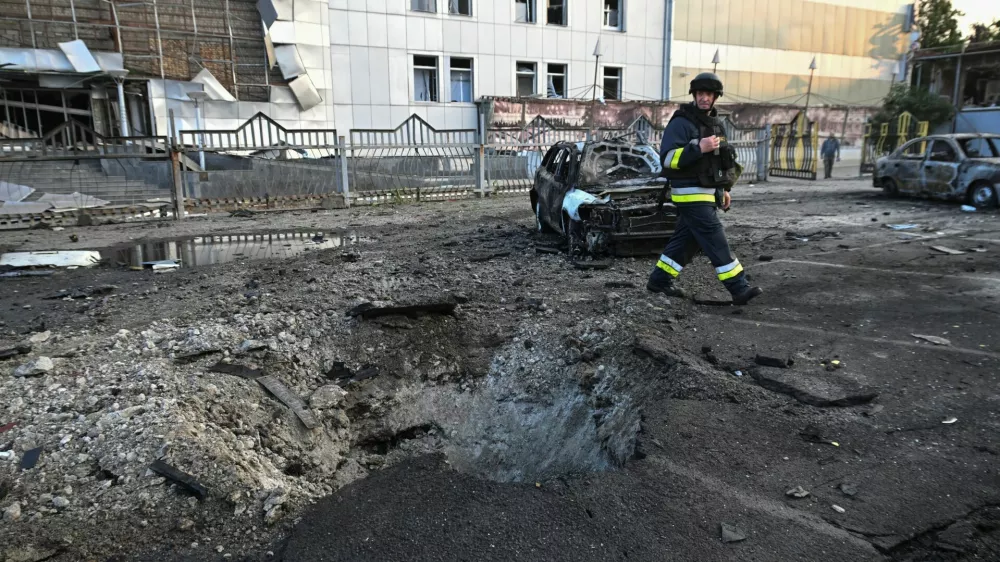 A rescuer walks next to destroyed cars and a building of shopping mall damaged by a Russian drone strike, amid Russia's attack on Ukraine, in Zaporizhzhia, Ukraine June 14, 2025. REUTERS/Stringer