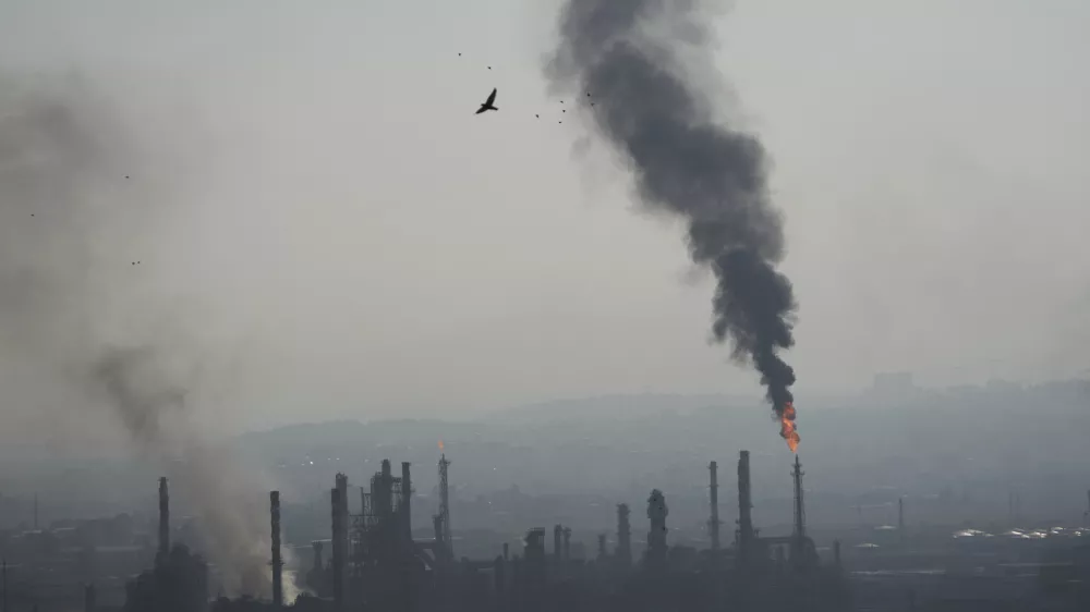 Smoke billows after an Iranian missile struck an oil refinery in Haifa, northern Israel, early Monday, June 16, 2025. (AP Photo/Ariel Schalit)