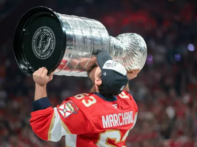 Jun 17, 2025; Sunrise, Florida, USA; Florida Panthers center Brad Marchand (63) hoists the Stanley Cup after winning game six of the 2025 Stanley Cup Final against the Edmonton Oilers at Amerant Bank Arena. Mandatory Credit: Sam Navarro-Imagn Images