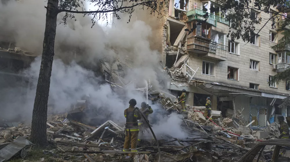 Firefighters put out the fire after a Russian missile hit a residential building during Russia's massive missile and drone air attack in Kyiv, Ukraine, Tuesday, June 17, 2025. (AP Photo/Efrem Lukatsky)