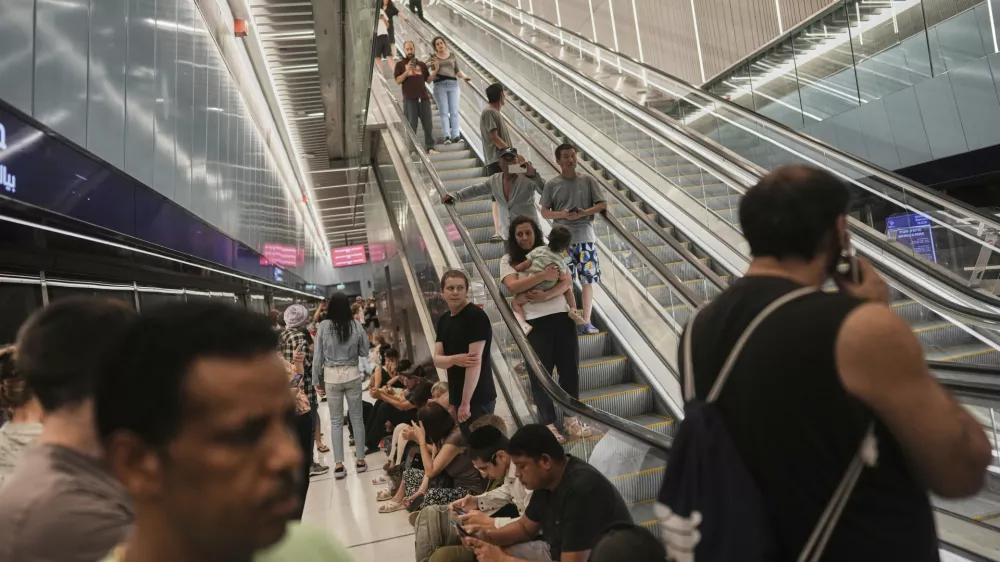 People shelter in an underground metro station as air raid sirens warn of incoming strikes by Iran, in Ramat Gan, near Tel Aviv, Israel, Wednesday, June 18, 2025. (AP Photo/Oded Balilty)