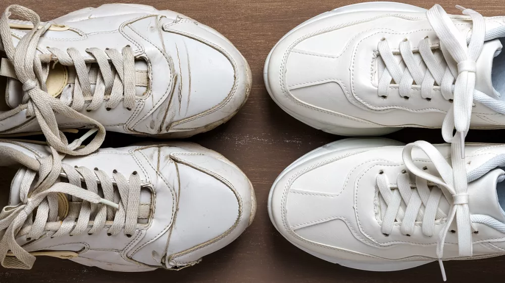 Pair of old dirty white sneakers in front of new clean one on a brown background. Past and future, old and new concepts. Comfortable shoes for active lifestyle, fitness and sports. Top view.