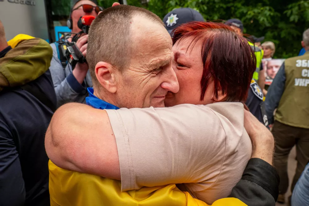 A Ukrainian soldier hugs his beloved as he returns from captivity after a POWs exchange between Russia and Ukraine, in Chernyhiv region, Ukraine, Thursday, June 19, 2025. (AP Photo/Dan Bashakov)